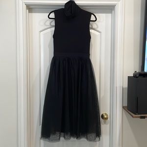 Black dress, no sleeves, tulle skirt and loose neck. Hope and Harlow dress